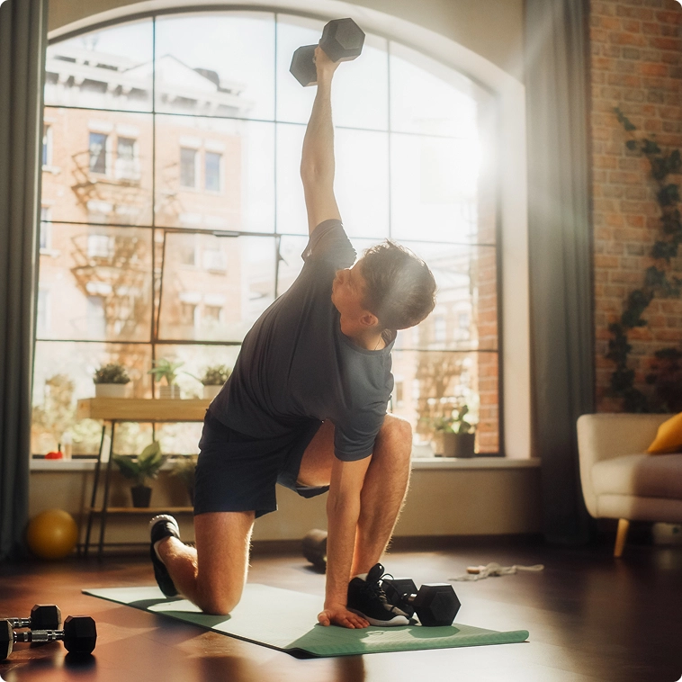 homem ajoelhado fazendo levantamento de halteres